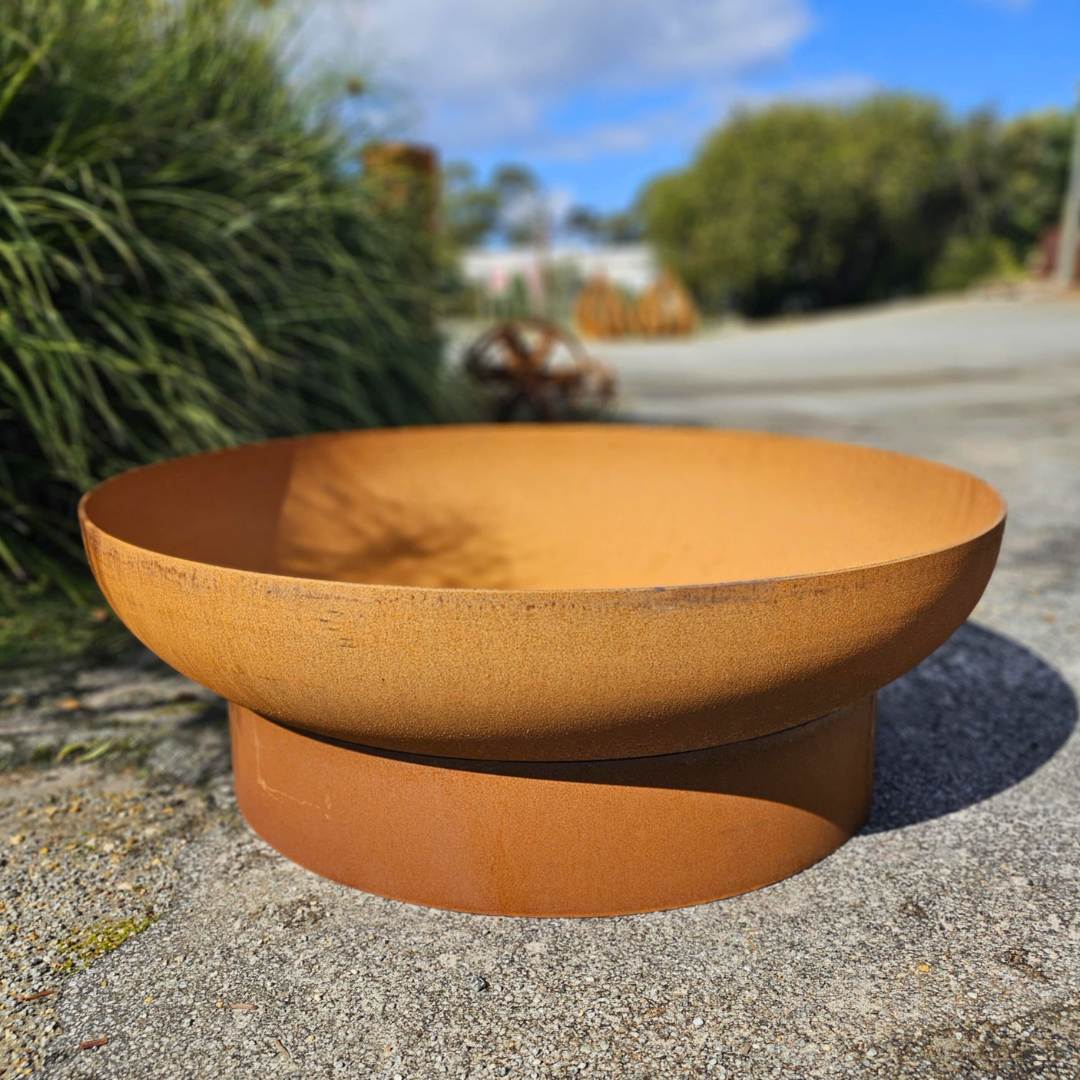 a rusted steel fire bowl resting on a corten steel ring at Designer Dirt
