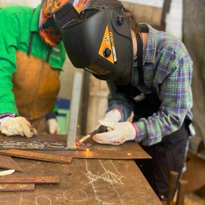 Learning how to weld with a MIG welder at a Designer Dirt workshop