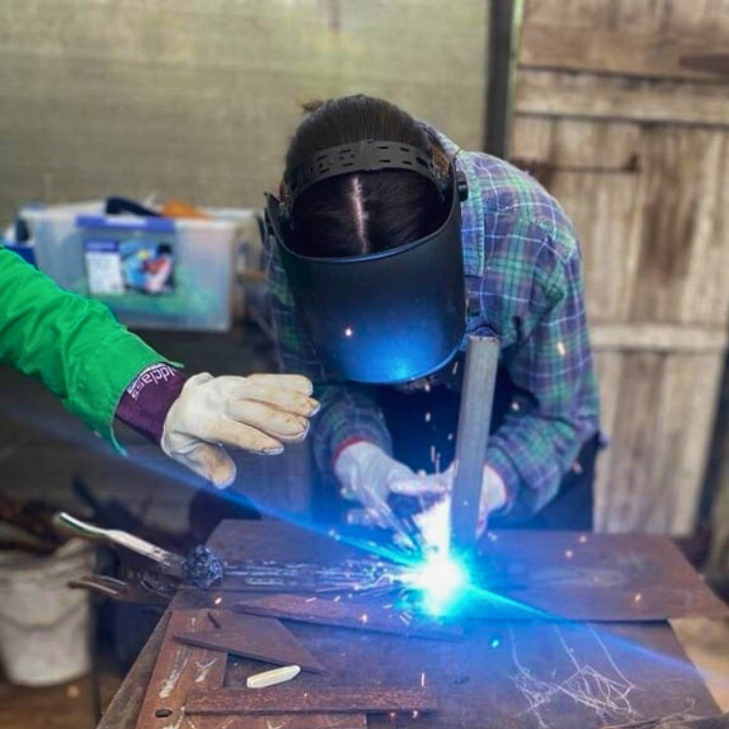 Practicing welding with a MIG at a Designer Dirt workshop