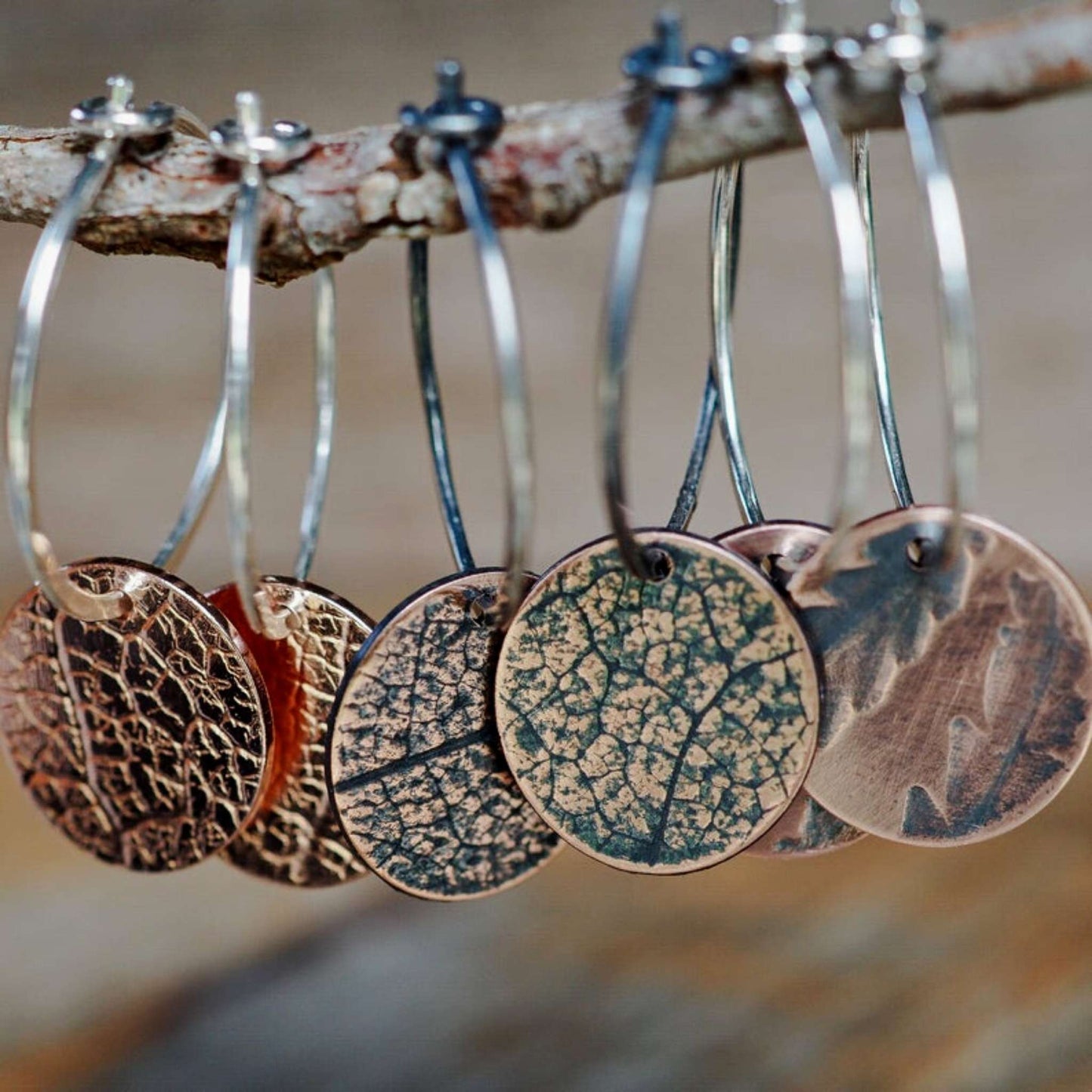 Copper leaf patterned disks on small sterling silver hoop earrings